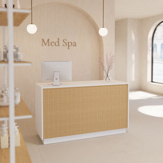 A modern reception desk in a spa setting, featuring a textured beige front panel and white frame, set against a matching beige arched wall with 'Med Spa' written in gold lettering.
