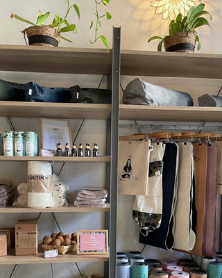 Shelves with bags, bottles, and clothing in a yoga studio setting